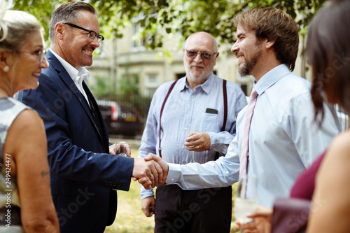 Men shaking hands at a party photo