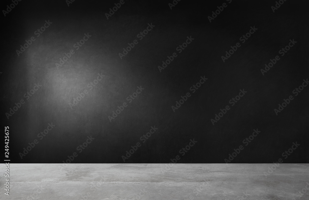 Black wall in an empty room with concrete floor Black wall in an empty room with concrete floor