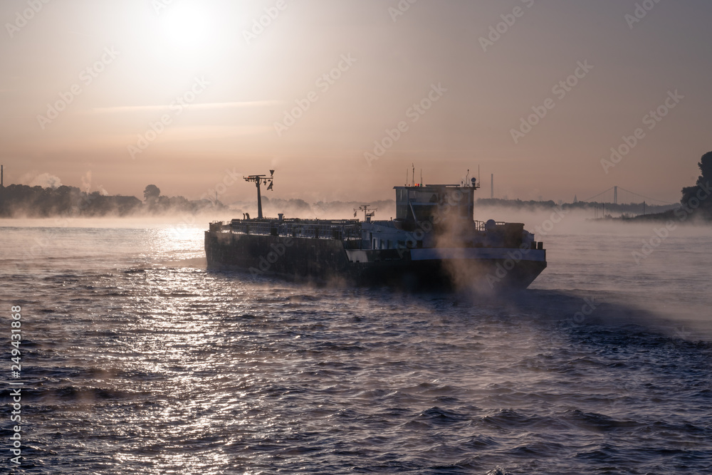 Shipping or cargo river boat on misty water at sunrise. Shipping or cargo river boat on misty water at sunrise.