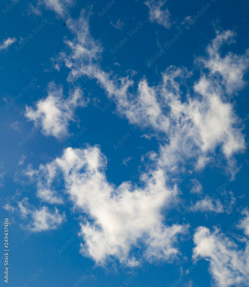 Smoky clouds float across a blue afternoon sky. Smoky clouds float across a blue afternoon sky.