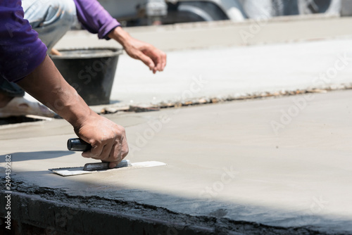 Plasterer concrete cement work. using a trowel to smooth or leveling concrete slab floor work step of the building construction.