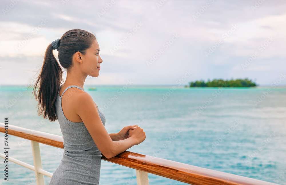 Cruise ship luxury Tahiti vacation island hopping French Polynesia Oceania world tour in yacht on tropical ocean travel - Young tourist Asian woman watching sunset on deck of cruising boat. Cruise ship luxury Tahiti vacation island hopping French Polynesia Oceania world tour in yacht on tropical ocean travel - Young tourist Asian woman watching sunset on deck of cruising boat.