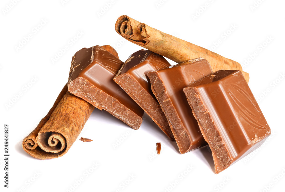 Tasty milk chocolate closeup with cinnamon sticks isolated on white background Tasty milk chocolate closeup with cinnamon sticks isolated on white background