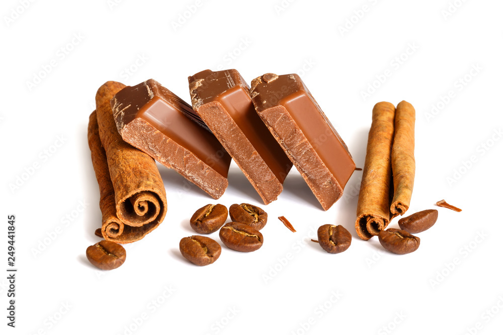 Tasty milk chocolate closeup with grains of coffee and cinnamon sticks isolated on white background Tasty milk chocolate closeup with grains of coffee and cinnamon sticks isolated on white background