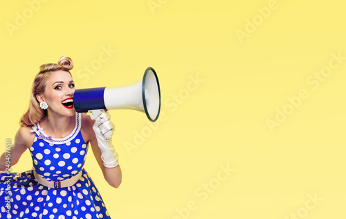 happy woman holding megaphone, dressed in pin-up style photo