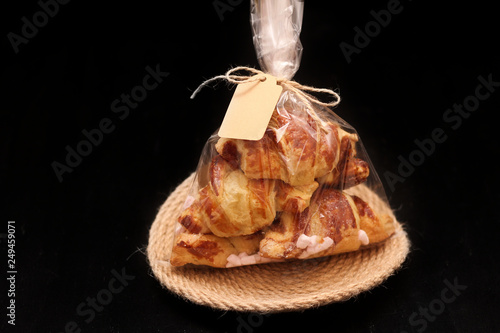 Billede på lærred Fresh homemade French croissants with filling in a transparent cellophane bag wi