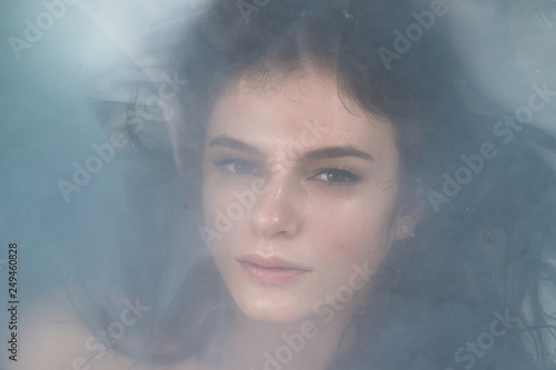 close portrait of a girl in smoke lying on her back