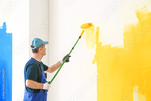 Male painter in uniform wor...