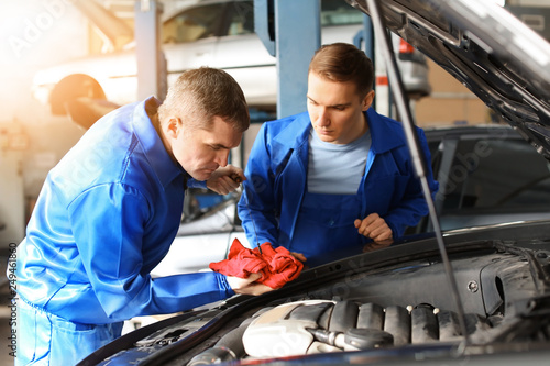 Male mechanics fixing car i...