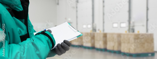 Schilderij op canvas Hand of worker with clipboard checking goods in freezing room or warehouse