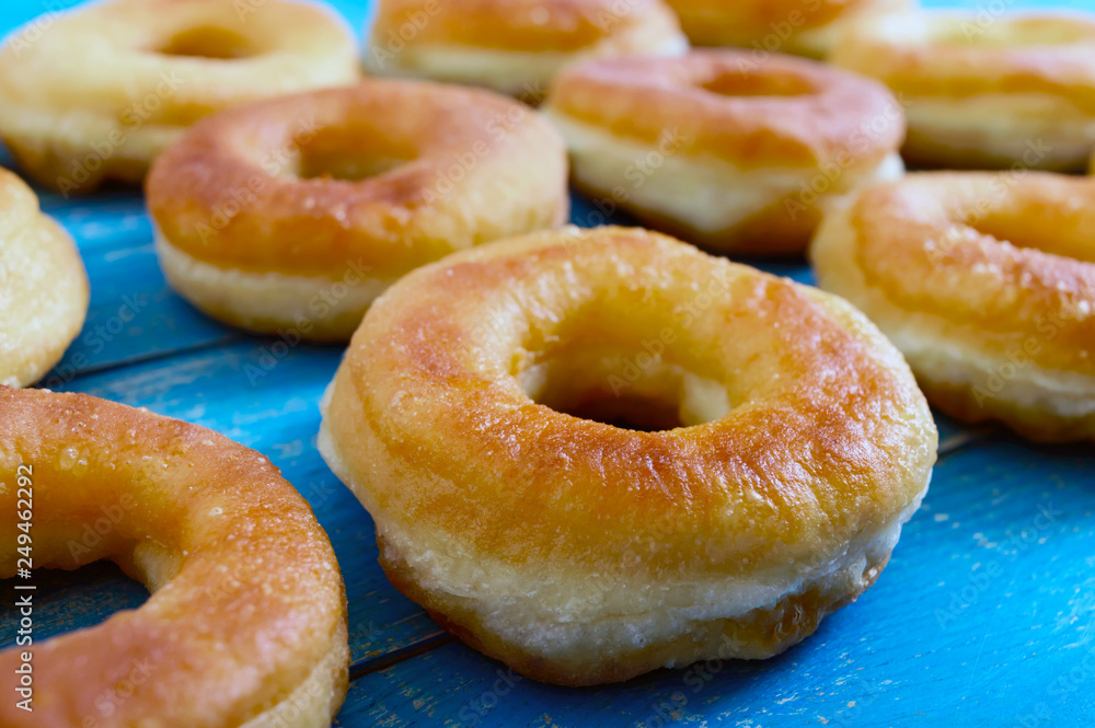 Homemade classic donuts on a blue wooden table. Close up.