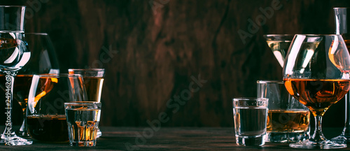 Selection of hard strong alcoholic drinks in big glasses and small shot glass in assortent: vodka, cognac, tequila, brandy and whiskey, grappa, liqueur, vermouth, tincture, rum.  photo
