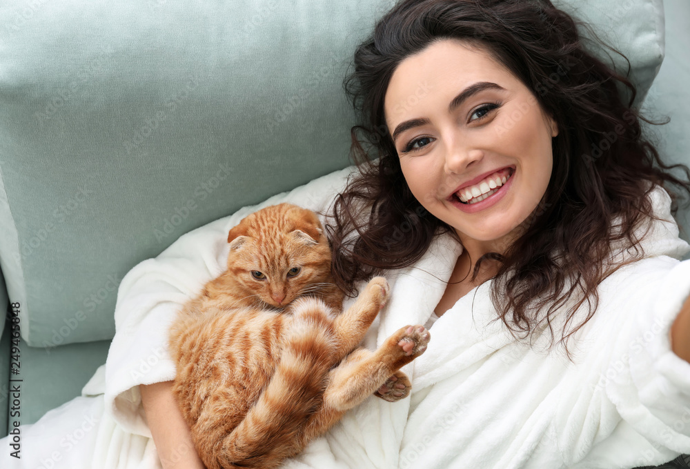 Young woman taking selfie with cute funny cat at home Young woman taking selfie with cute funny cat at home
