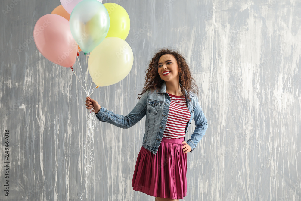 Carefree young woman with balloons near grunge wall Carefree young woman with balloons near grunge wall