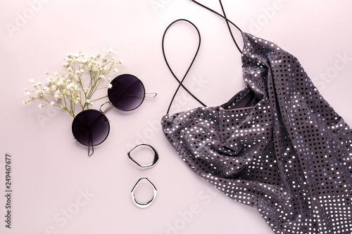 Stylish female dress with accessories on light background