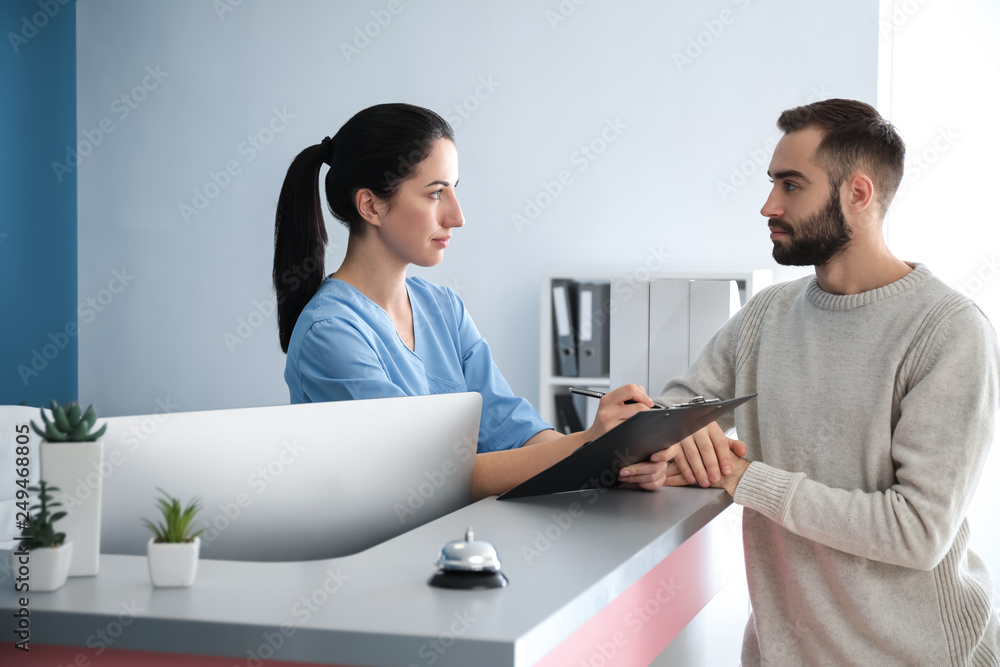 Young man near reception desk in clinic