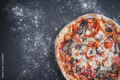 Pizza with vegetables on a dark background