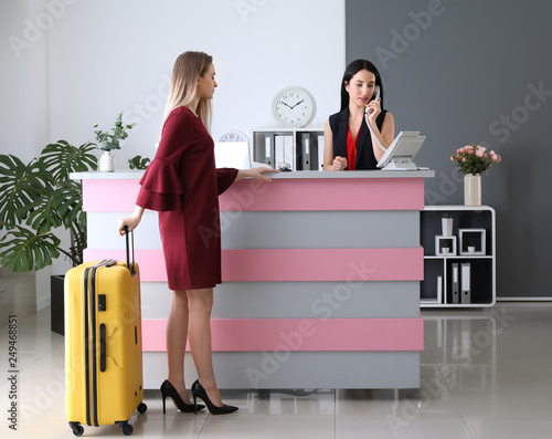 Young woman near reception desk in hotel