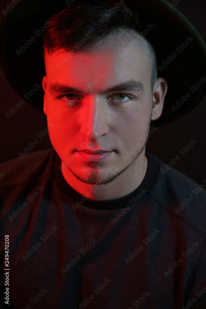 Fototapeta premium Toned portrait of handsome young man on dark background