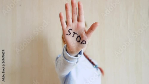 Concept of domestic violence and child abusement. A little girl shows her hand with the word STOP written on it. Children violence. photo