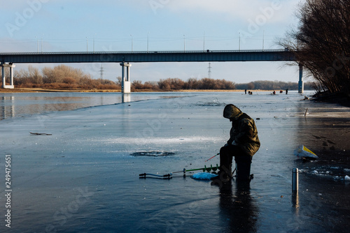 A man is fishing on the ice in the winter. Winter fishing