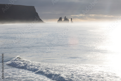 Famous basalt sea stacks of Reynisdrangar, rock formations on the black sand of Reynisfjar beach, view not far from Vik, a small village in southern Iceland. Troll Fingers photo