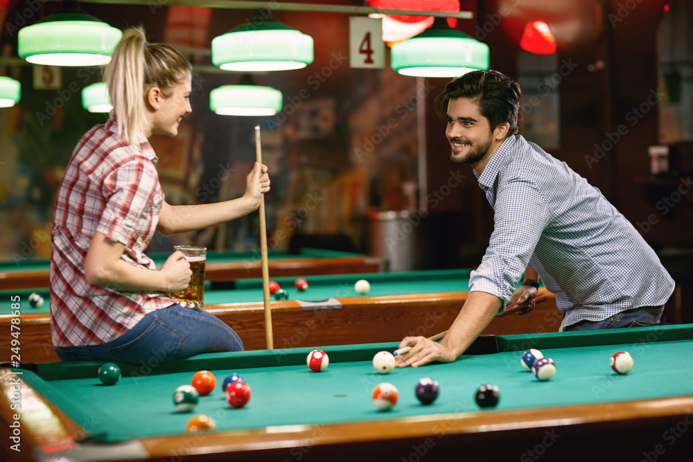 Fototapeta premium young couple enjoying playing billiard .