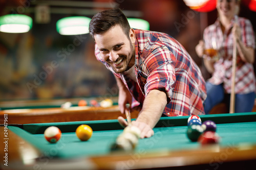 Young smiling man playing billiard . photo
