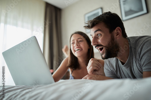 people, family, bedtime and fun concept -Couple with laptop in bed surfing on the net at laptop.