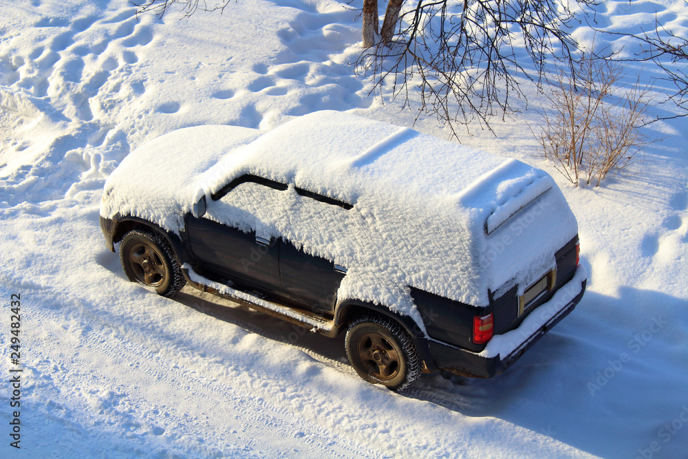 Old SUV covered with snow. View from above. Close-up. Background. Old SUV covered with snow. View from above. Close-up. Background.
