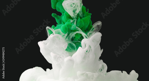 Green and white color paint drops in water
