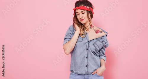 Portrait of a stylish girl in denim clothes on a pink background