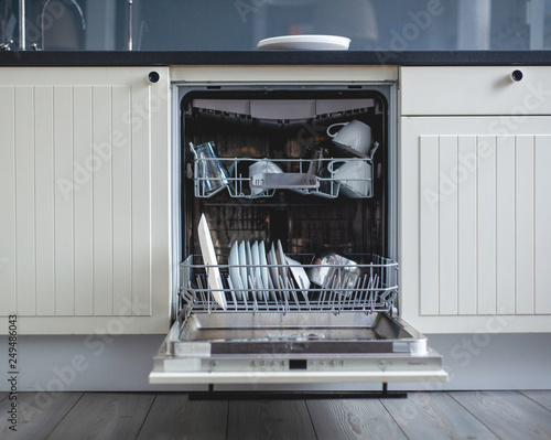 Modern kitchen. High angle view of utensils in dishwasher at kitchen photo