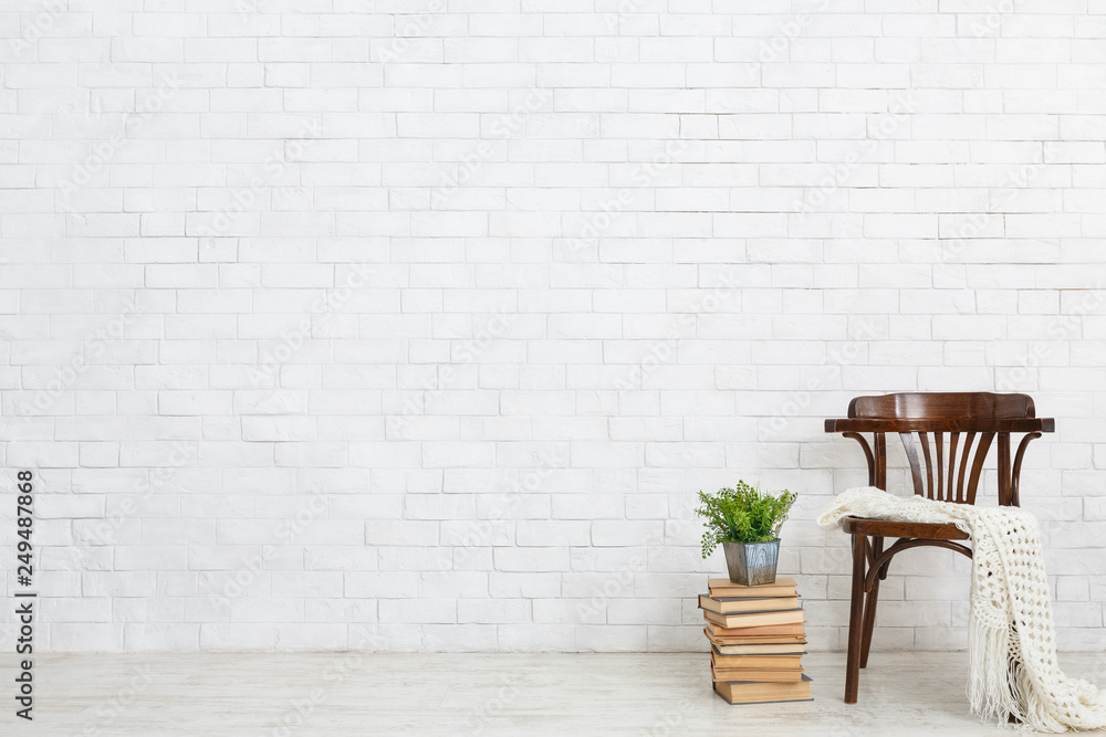 Wooden chair, books and plant on the floor