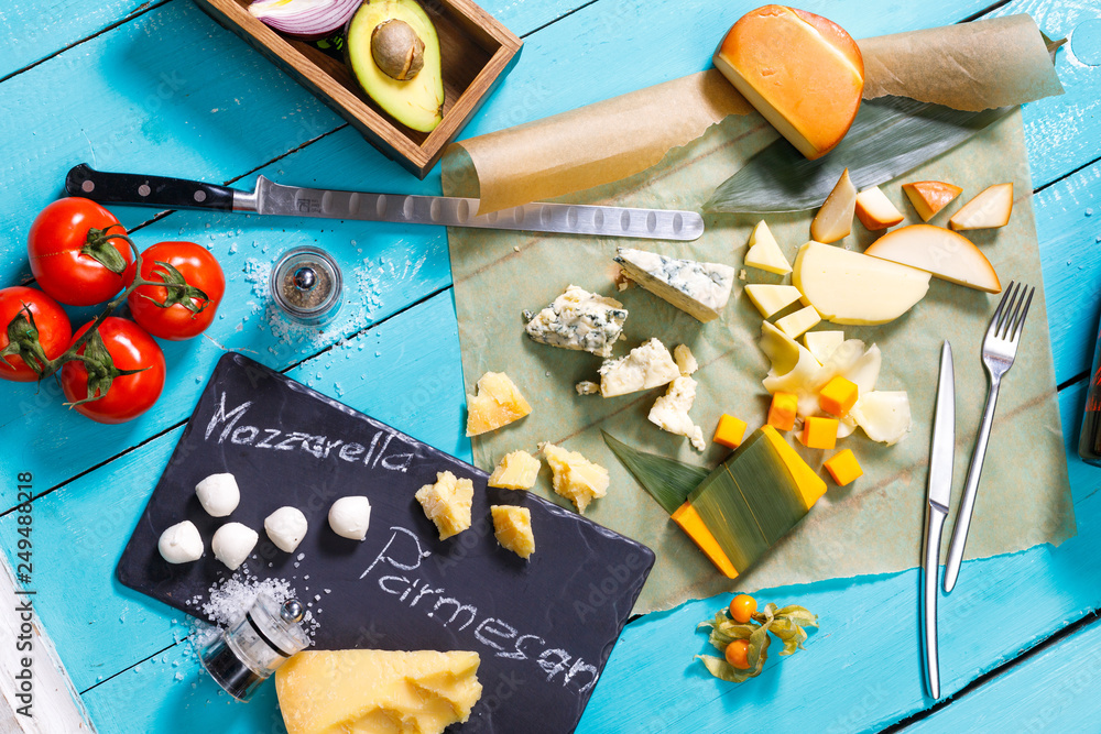 different types of cheese on a blue wooden table