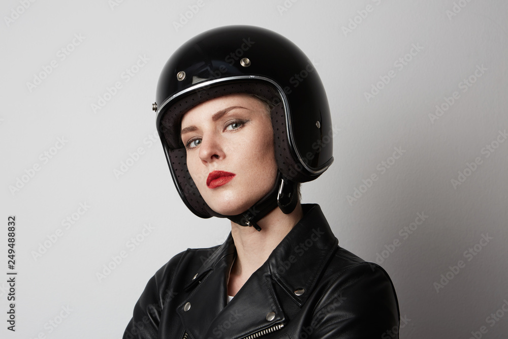 Headshot Portrait of fashion girl with red lips in black leather jacket smiling looking at camera over white background. Fashion, glamour and transportation concept Headshot Portrait of fashion girl with red lips in black leather jacket smiling looking at camera over white background. Fashion, glamour and transportation concept