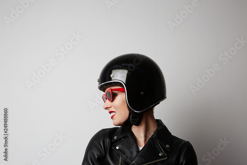 Fabulous woman with red lips in black leather jacket smiling looking at camera over white background. Fashion, glamour and transportation concept © KleverLevel
