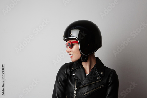 Fabulous woman with red lips in black leather jacket smiling looking at camera over white background. Fashion, glamour and transportation concept.Cropped