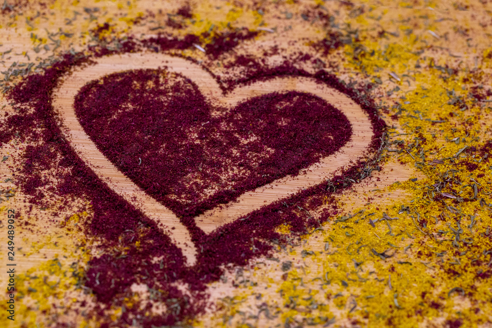 cutting wooden Board with spices poured on it in the form of a heart cutting wooden Board with spices poured on it in the form of a heart