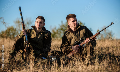 Hunting with friends hobby leisure. Hunters friends enjoy leisure. Hunters satisfied with catch drink warming beverage. Rest for real men concept. Hunters with rifles relaxing in nature environment