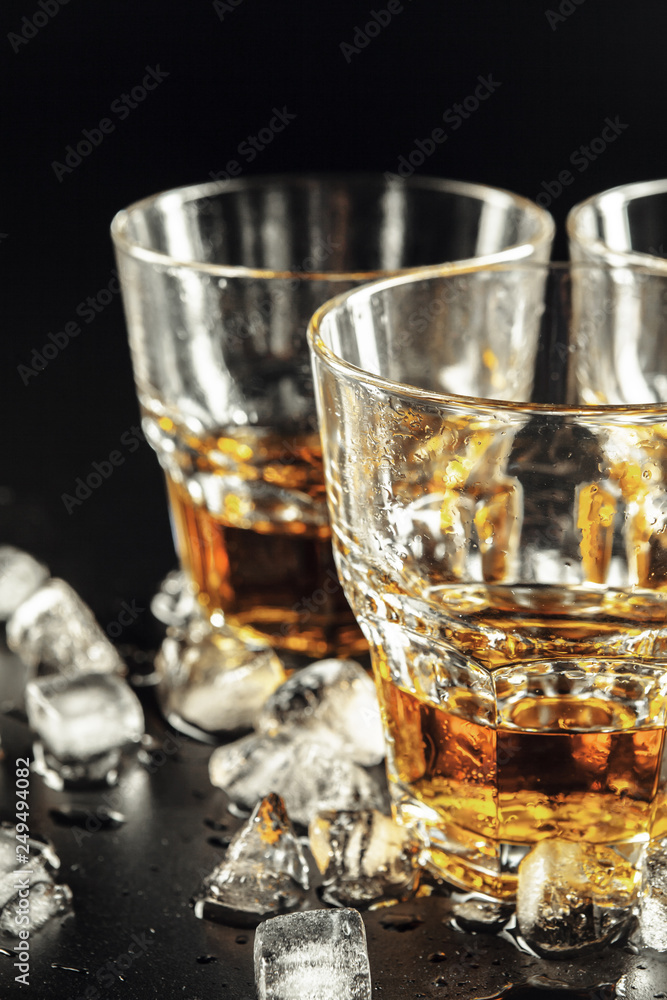 Whiskey and ice on rustic wood background