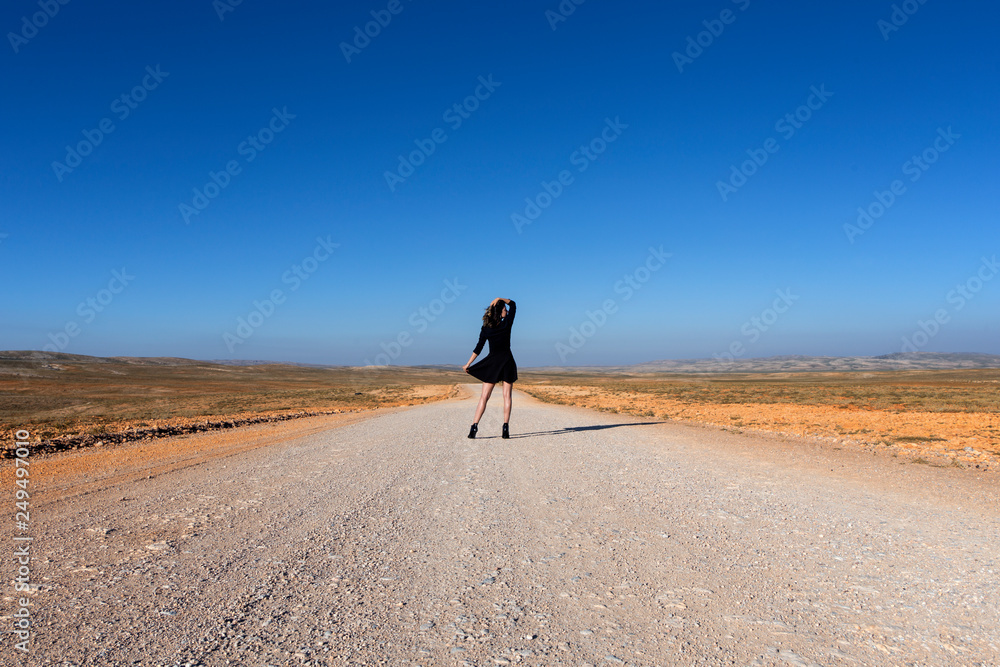 Φωτογραφία The gypsy woman black dress black shoes on the road.