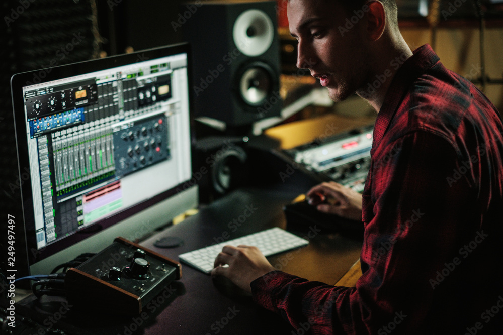 Sound engineer working in a music studio Sound engineer working in a music studio