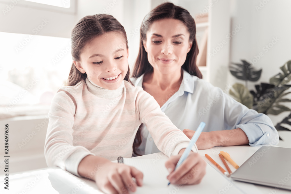 Pleasant-looking mature woman watching her little disciplinable daughter Pleasant-looking mature woman watching her little disciplinable daughter