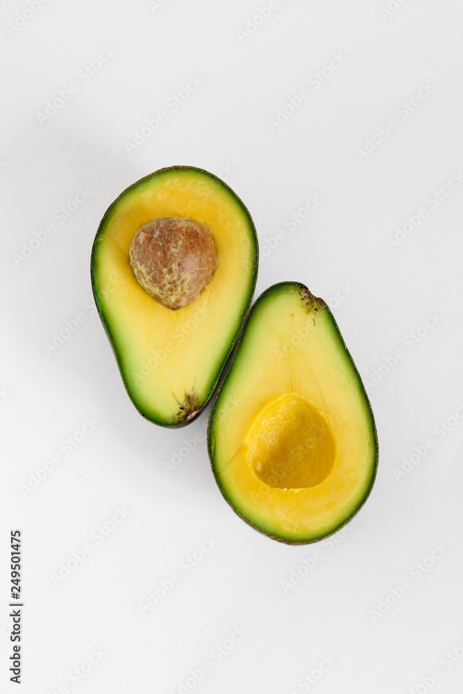 Whole and cut in half of avocado isolated on white background.