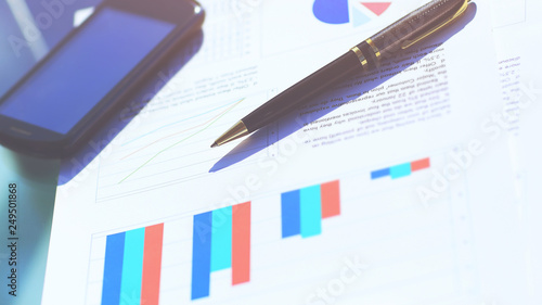 Financial charts on the table with tablet and pen