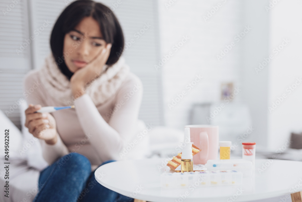 Bored brunette woman looking at medicine