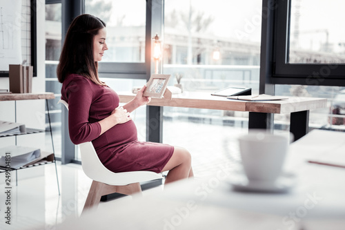 Young woman on maternity leave feeling contended near French window Free Download Young woman on maternity leave feeling contended near French window - GFXLoad