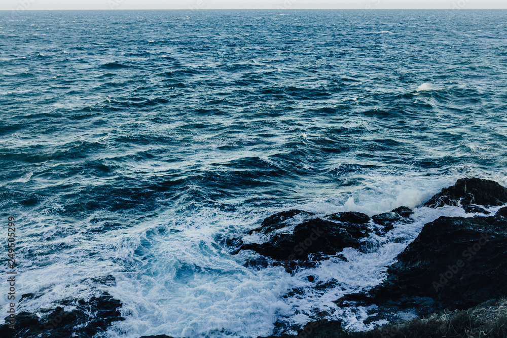 Fototapeta premium Waves in a turbulent and powerful sea, a windy day. Color blue.