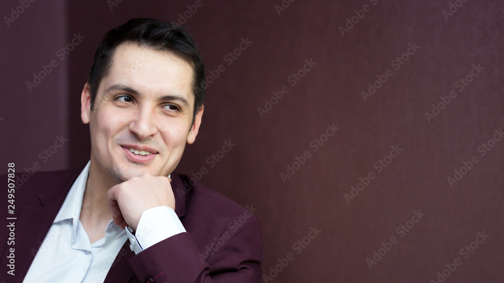 Handsome brunette man sitting on the sofa, a place for an inscription. Handsome brunette man sitting on the sofa, a place for an inscription.